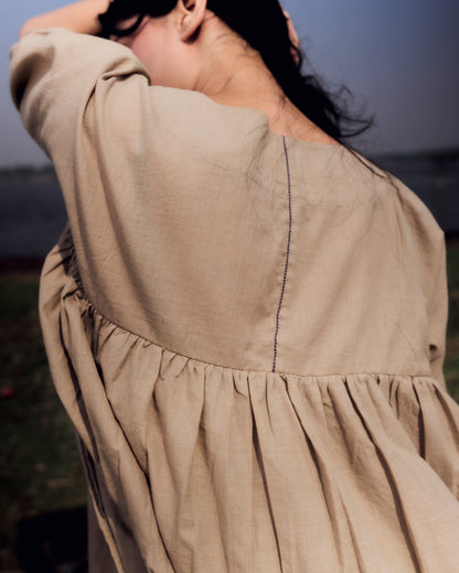 Close-up of a beige dress with a blurred background