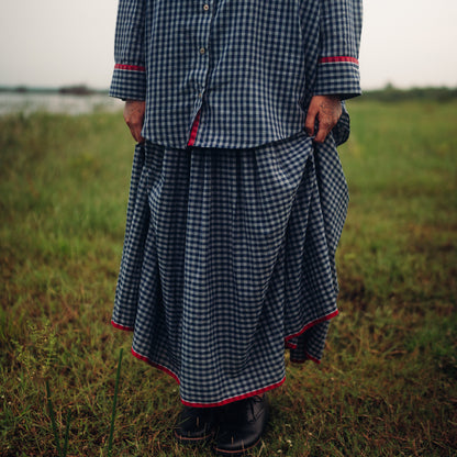 Person wearing a checkered outfit standing in a field
