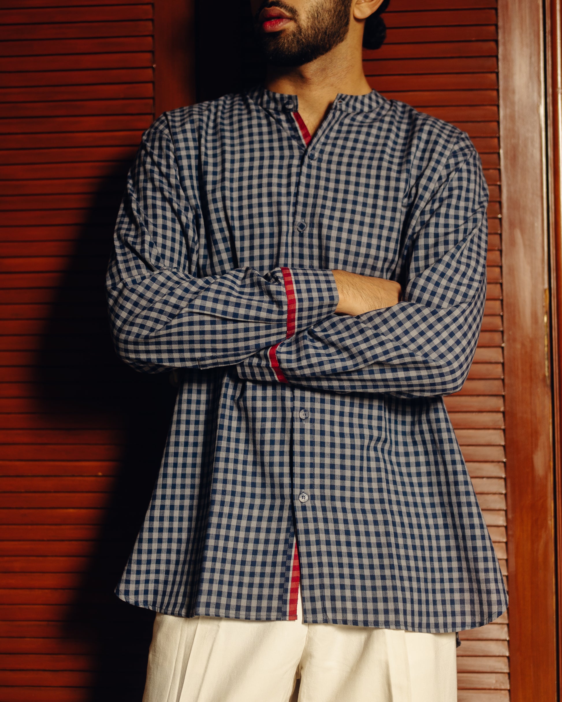Person wearing a blue and white Blueberry checks - full sleeve shirt with red accents against a wooden background