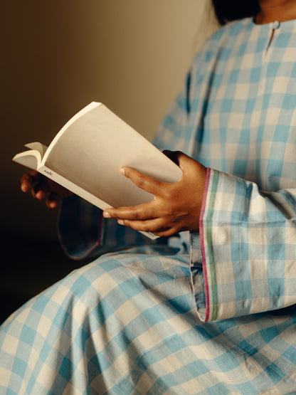 Person in Free size kurta - Light blue checks holding an open book