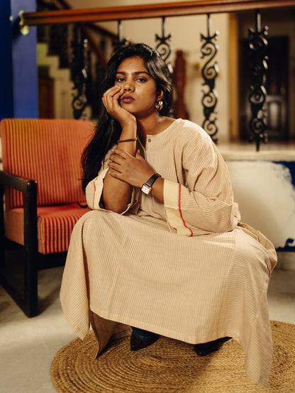 Person wearing a white traditional outfit with a watch on a blurred background