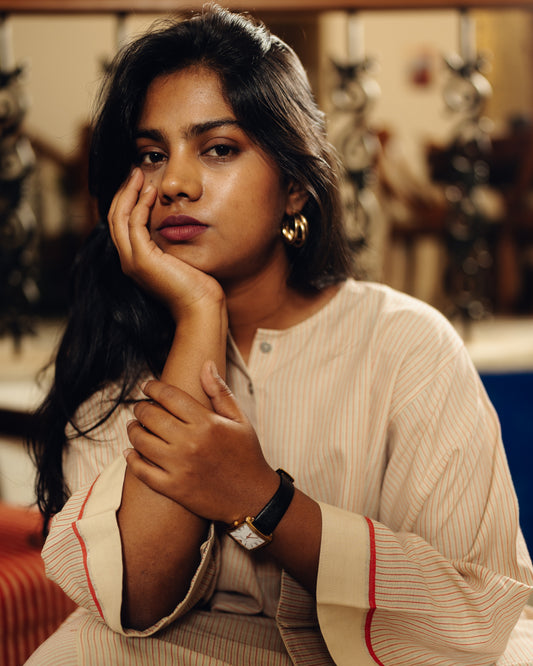 Woman wearing a Free size kurta - sand stripes with hand on chin in a casual indoor setting