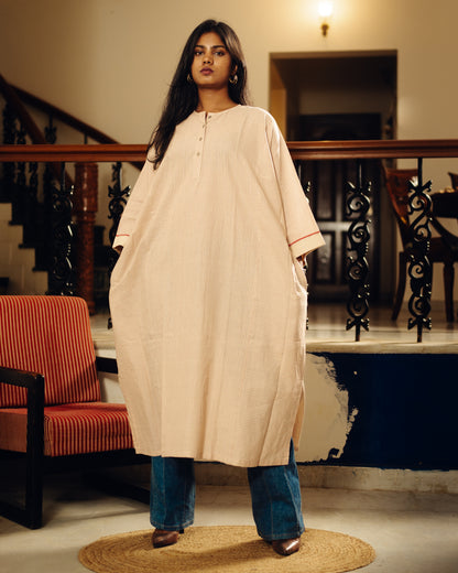 Woman wearing a Free size kurta - sand stripes with blue jeans in an indoor setting.
