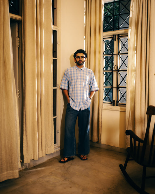 Man standing in a room with large windows and curtains
