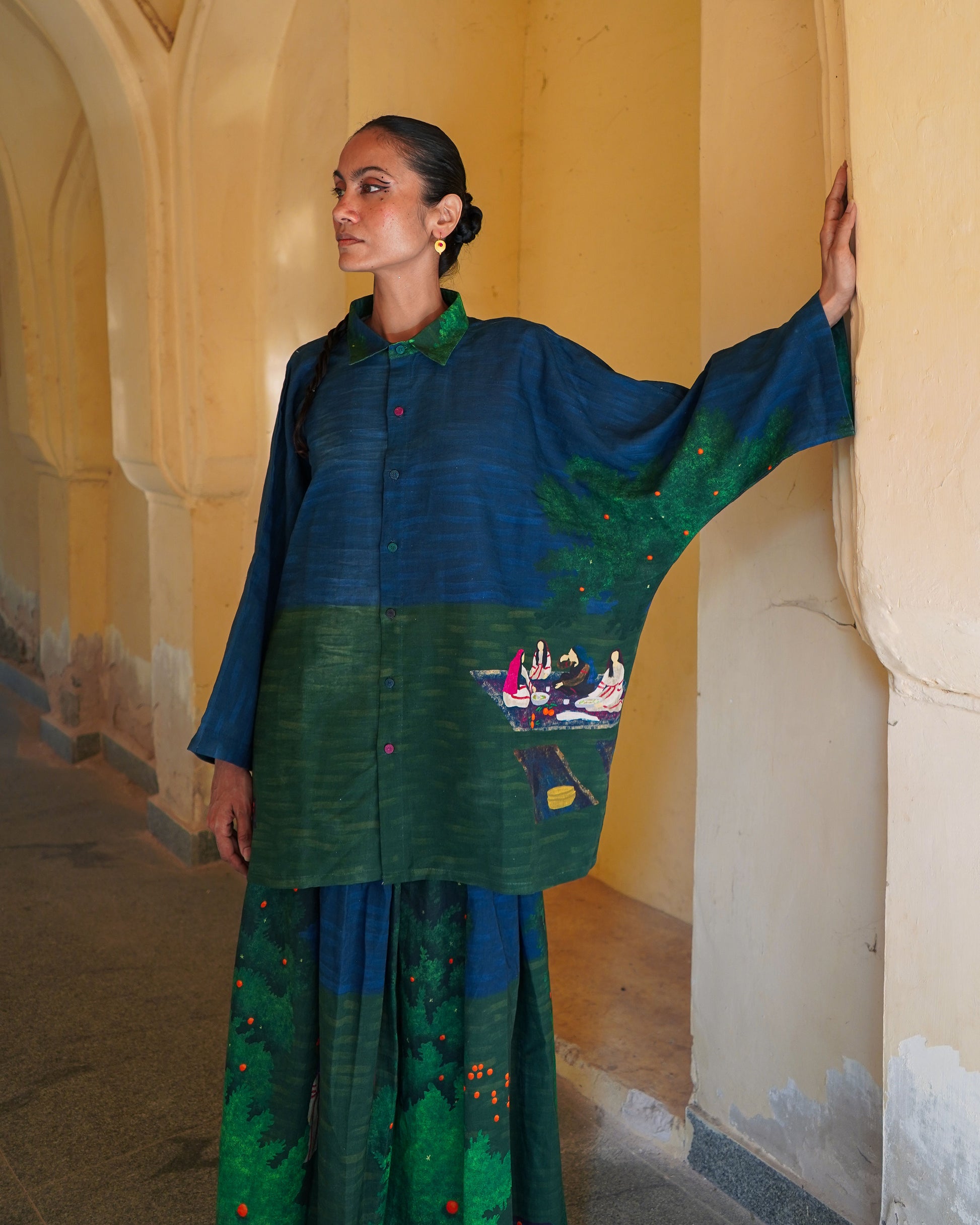 Woman wearing a traditional outfit with intricate designs in a historical setting