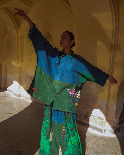 Woman in traditional green and blue outfit dancing in a sunlit hallway