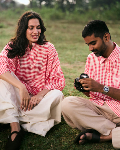 Two people sitting on the grass, one holding a camera.