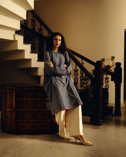 Woman in a checkered Kurta - Blueberry Checks standing in a staircase interior setting