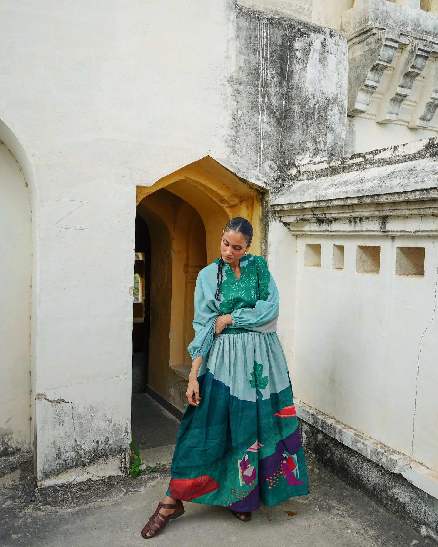 Woman in a colorful dress standing in an architectural setting