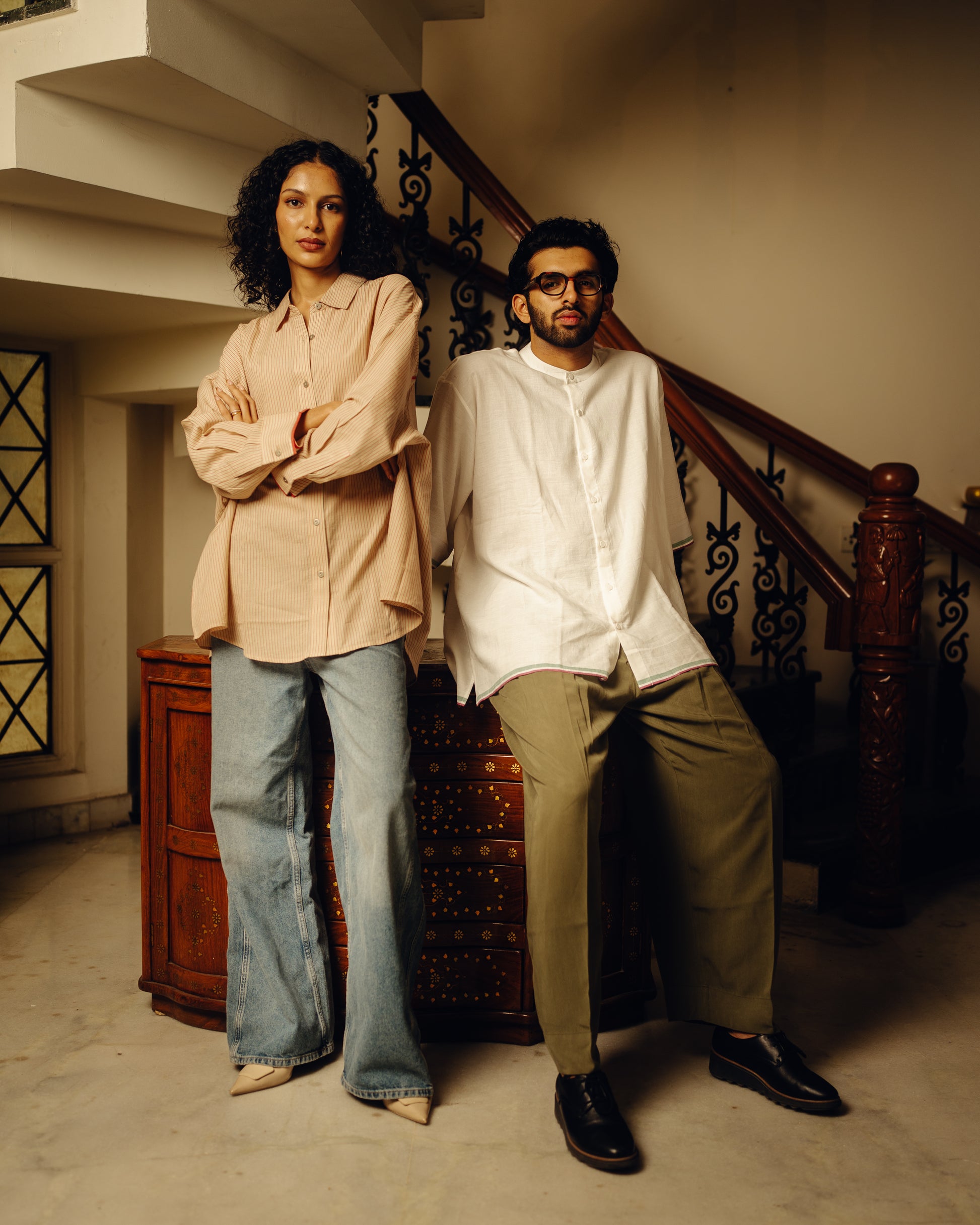 Two people standing on a staircase in an indoor setting