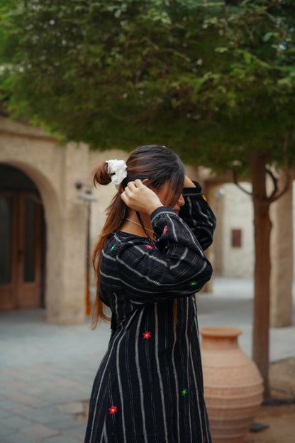 Woman adjusting her hair outdoors with a blurred background