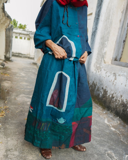 Person wearing a long, colorful dress with a patterned design outdoors.