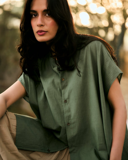Woman wearing a green shirt with a blurred natural background