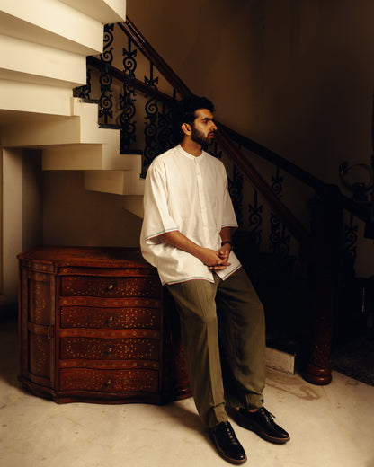 man in checkered pajamas sitting on a couch