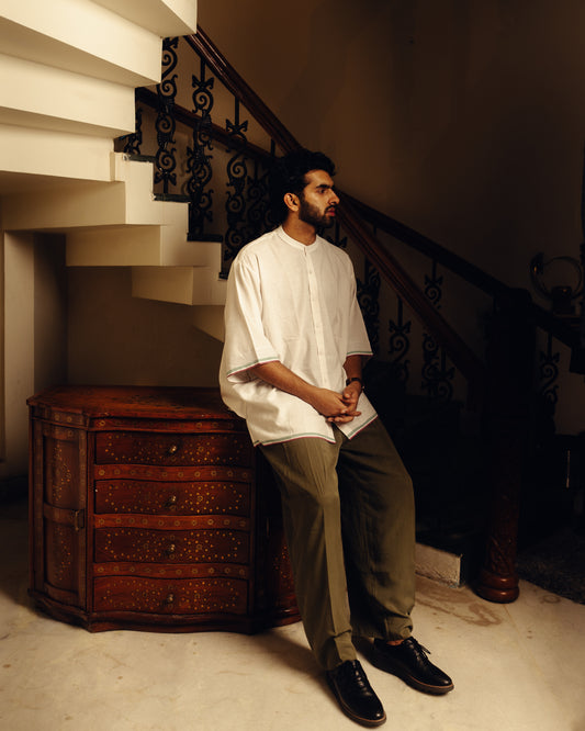 man in checkered pajamas sitting on a couch