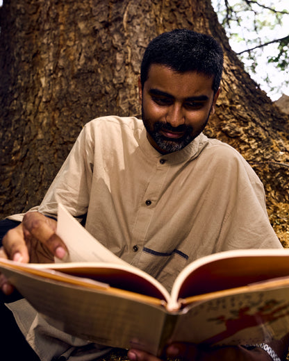 Man reading a book under a tree